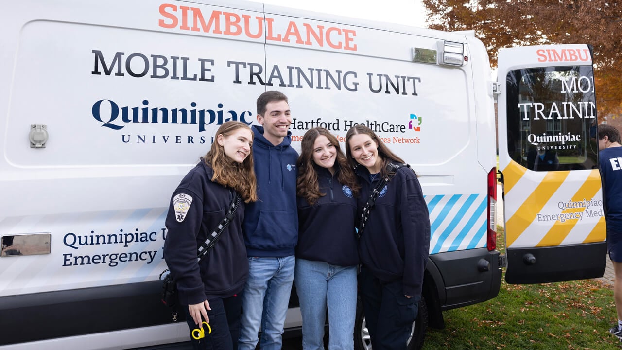 QU EMS students standing in front of a "simbualance" donated by Hartford HealthCare