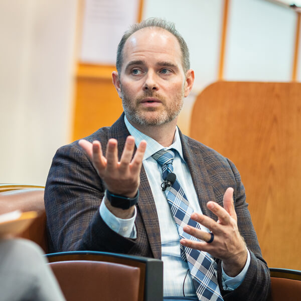 Eric Marrapodi sits in a leather chair in the Mount Carmel Auditorium speaking with a conversation moderator
