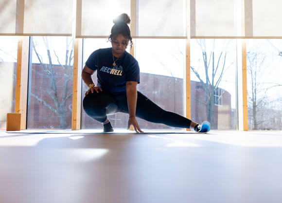 Girl stretching in a yoga pose on a mat.
