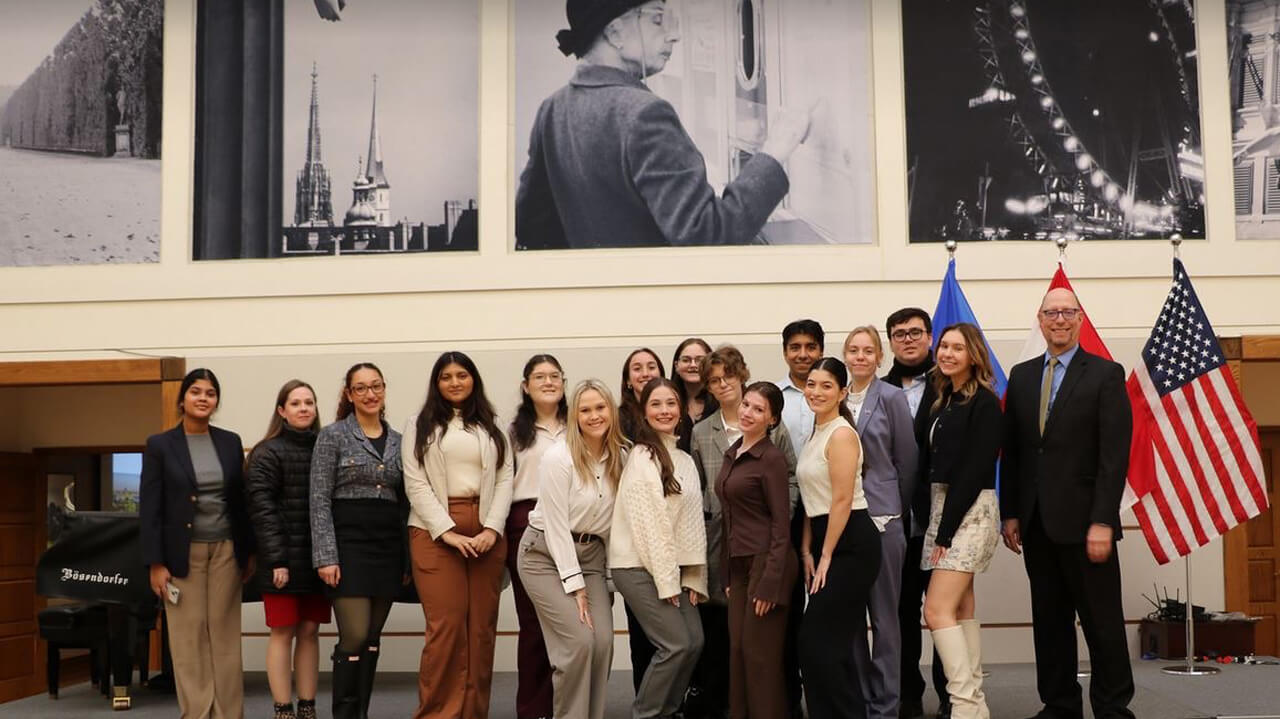 Quinnipiac honor students posing in front of political photos