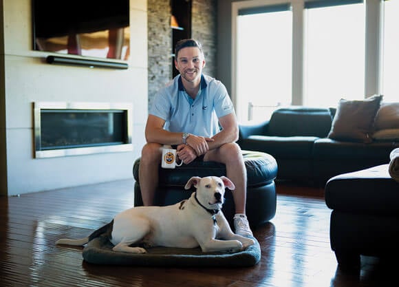 Former Quinnipiac hockey player TJ Friedmann poses with his dog, Charlie Bleu, the namesake for his coffee label