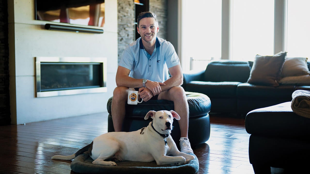 Former Quinnipiac hockey player TJ Friedmann poses with his dog, Charlie Bleu, the namesake for his coffee label