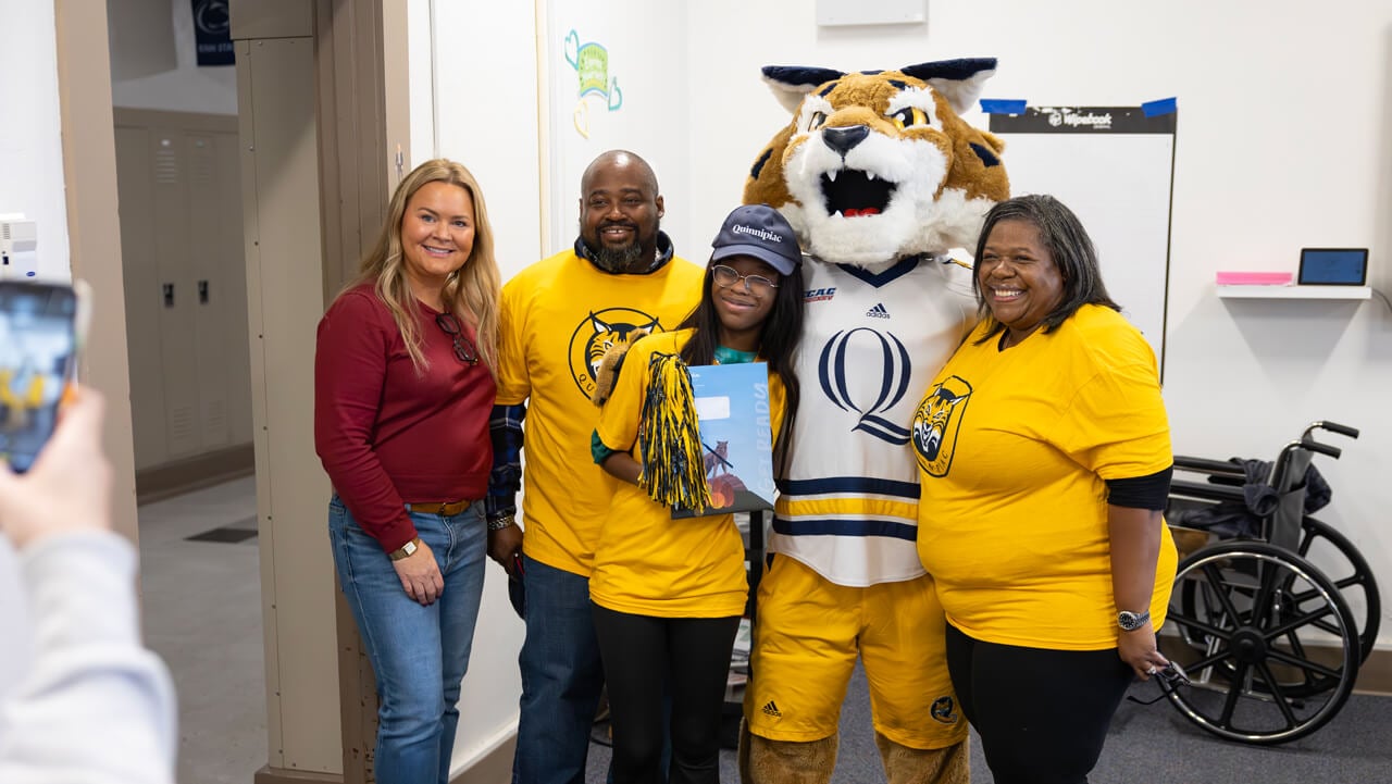 A new student poses with her family and Boomer the mascot