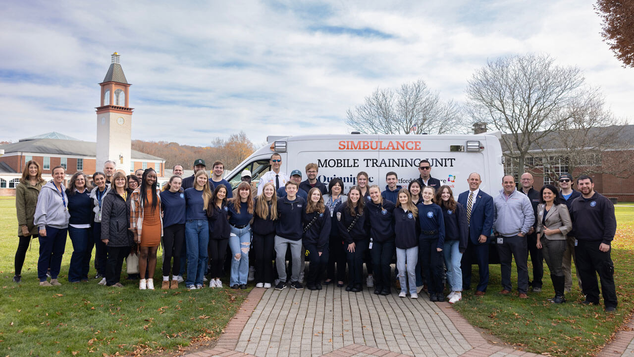 EMS Club students stand in front of decommissioned ambulance donated from Hartford HealthCare