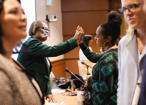 Two women high-five.