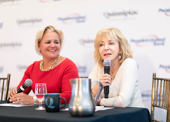 Sara Longobardi and Judy Olian sit at a table talking.