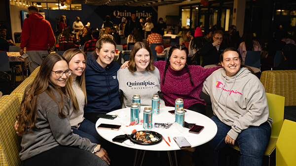 A group of students sit at a table together in the North Haven Dining Hall.