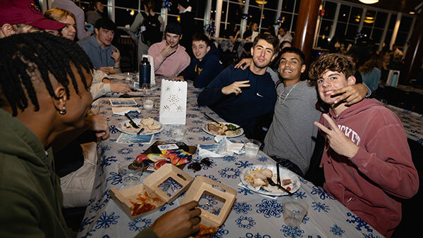 A group of students eat dinner together in the dining hall.