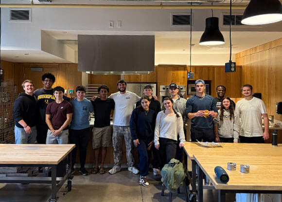 Members of the 1929 Fund smile for a photo in the demo kitchen.