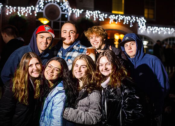 Students smile at the holiday lighting.