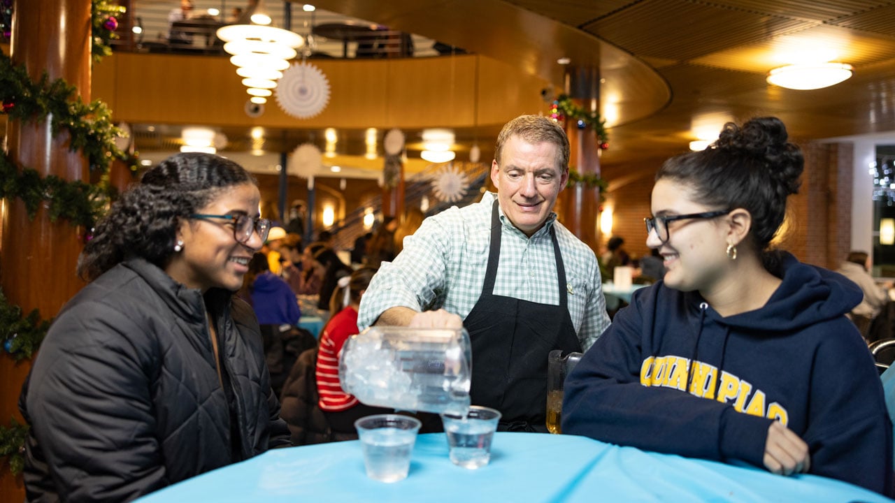 Quinnipiac staff member serves beverages for students