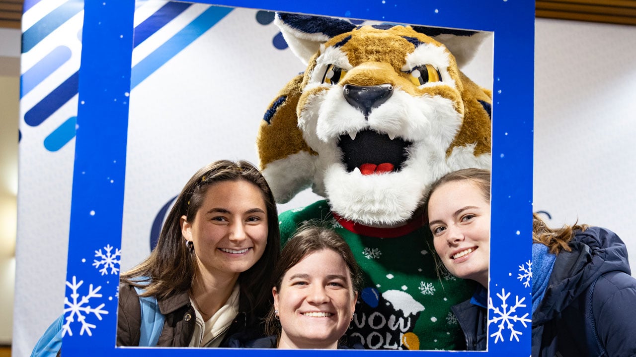 Boomer and students pose in front of the photo booth during the holiday dinner