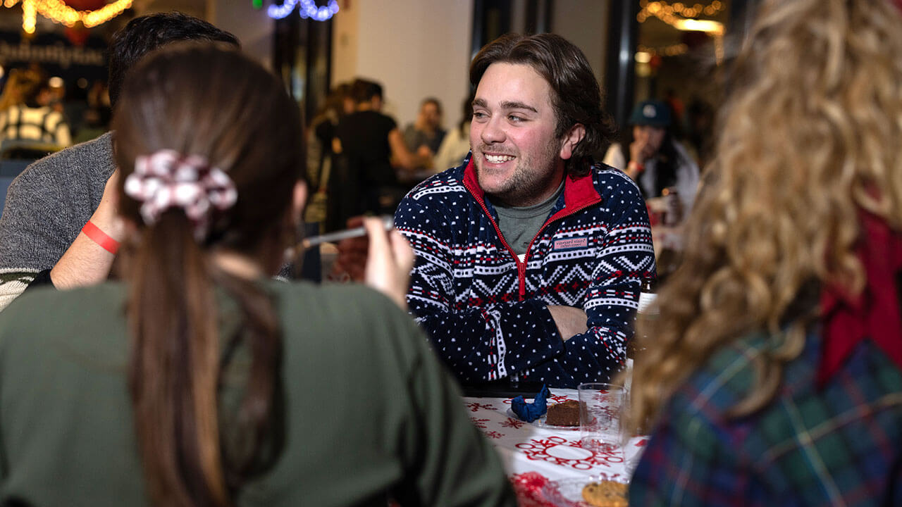 Graduate students enjoy conversations as they sit for a holiday meal