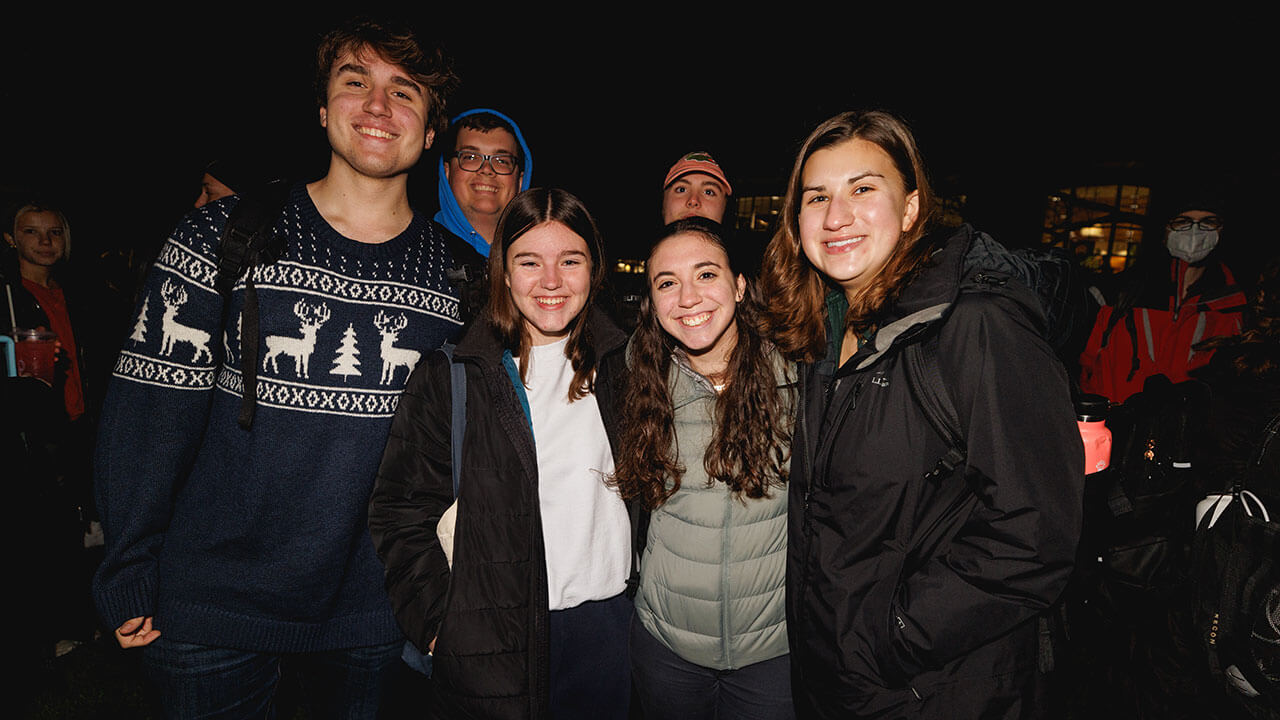 Students smile for a photo on the Quad during the Quad lighting.