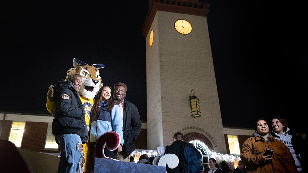 A group of students take a photo with Boomer