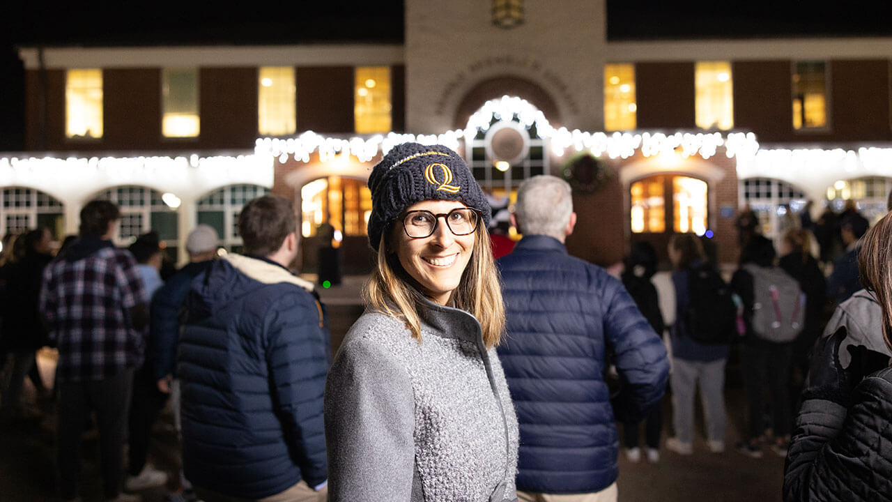 Students take a photo in front of the lit up library