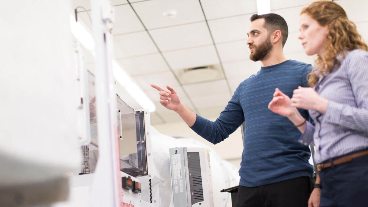 Two students working with the School of Engineering's water flow simulator