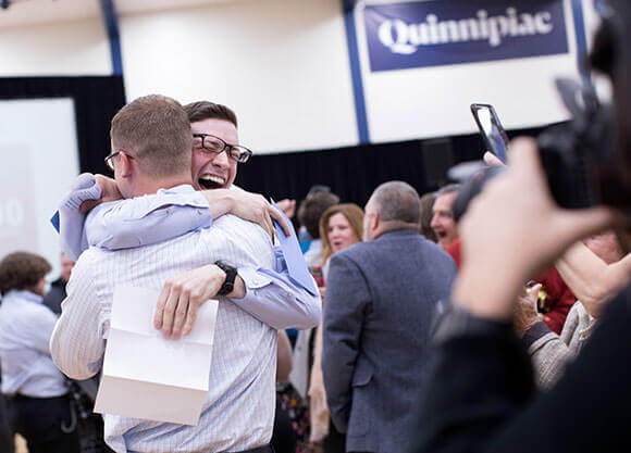Two students hug