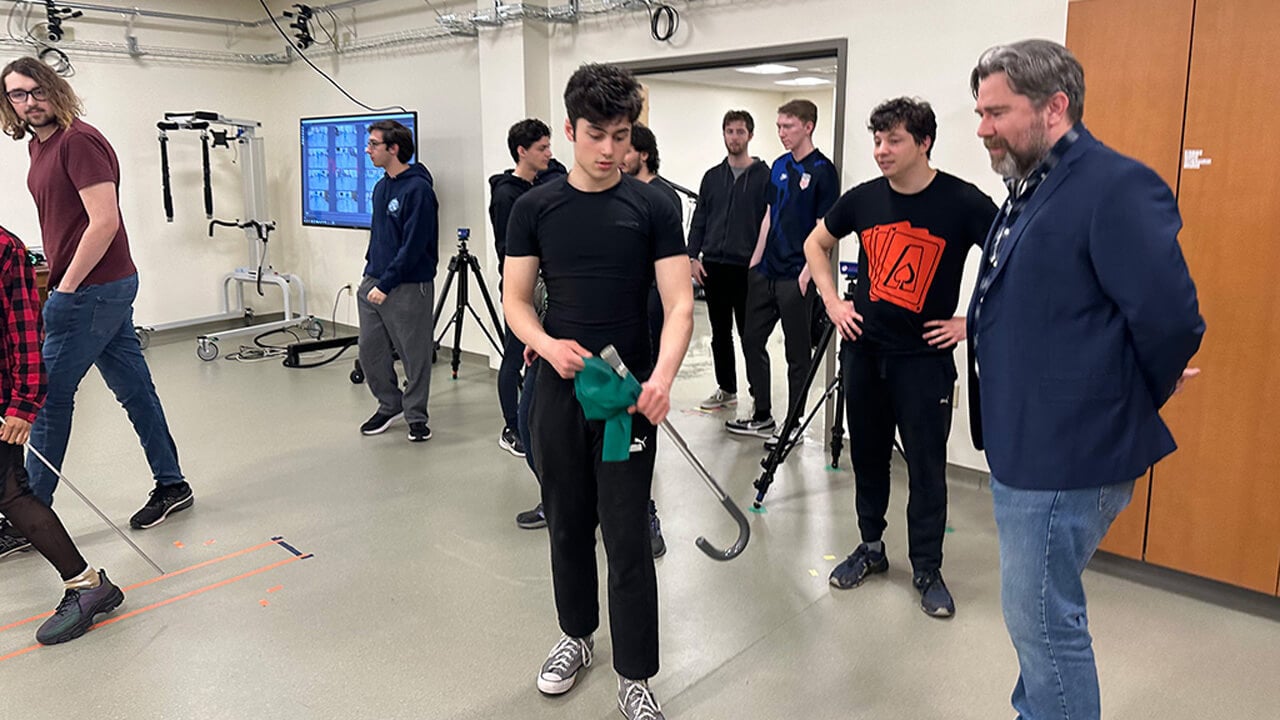 A group of students and faculty test out motion capture equipment in a classroom.